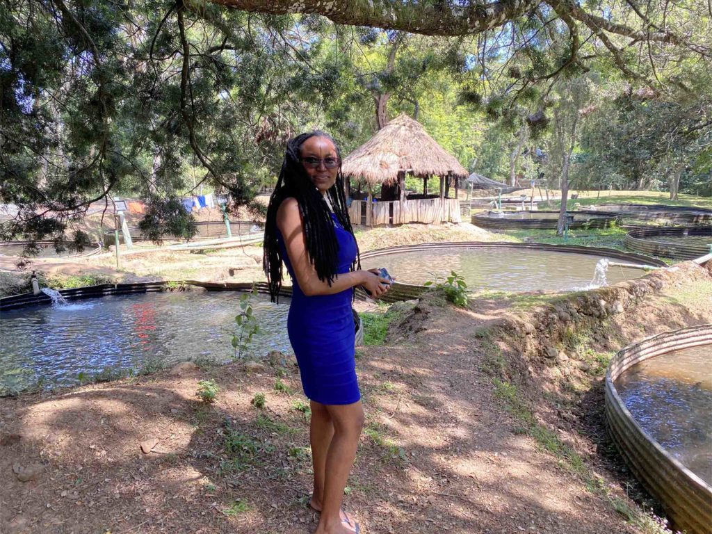 A young lady in a blue dress standing by a fish pond at The Trout Tree Restaurant