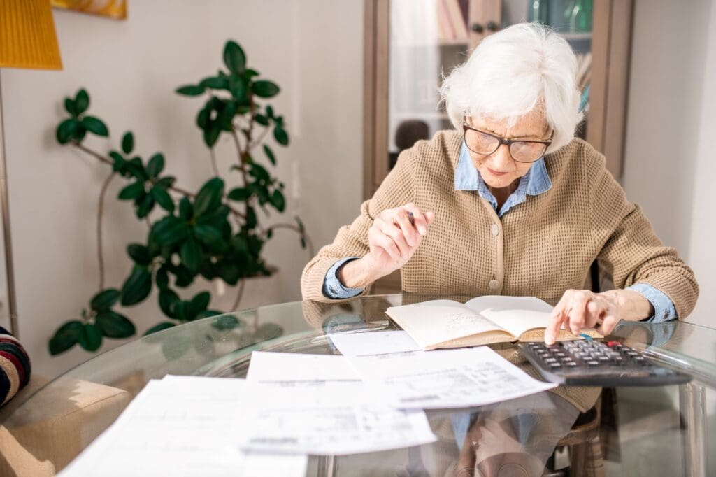 An elderly white lady doing budget calculations