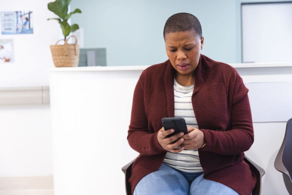 worried-african-american-female-patient-using-smartphone-