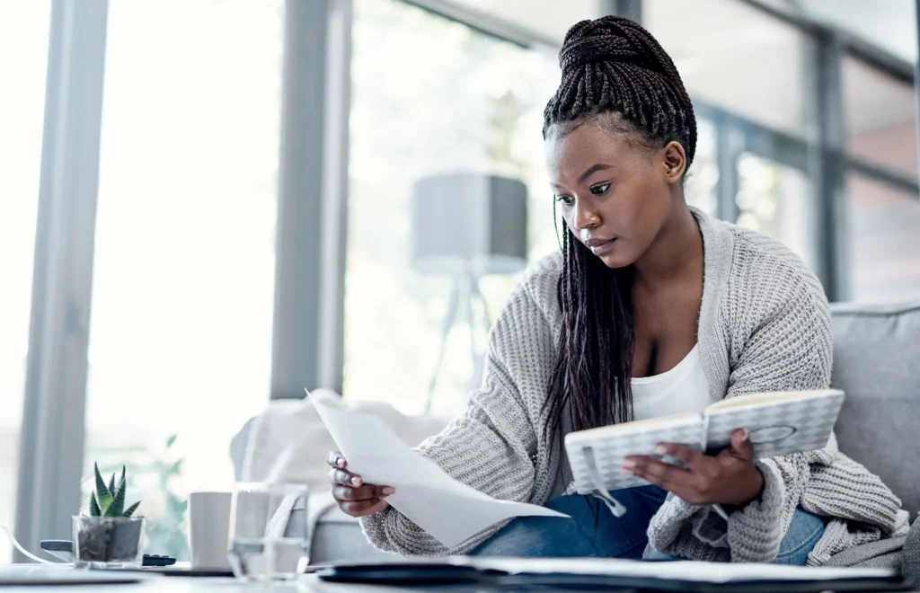 Young-African-Lady-Looking-at-papers-and-note-book