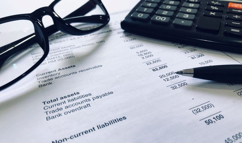 Calculator, pen, eye glasses and balance sheet statement