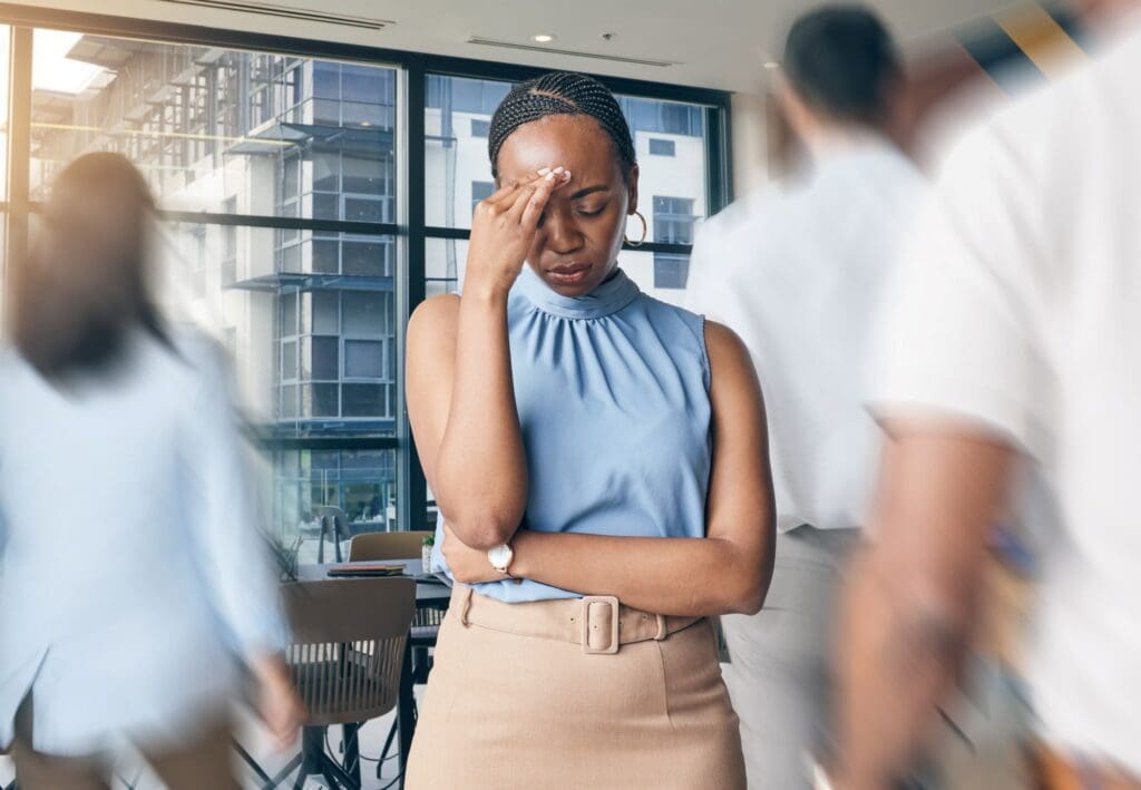 Stressed Black woman with blurred people in the background