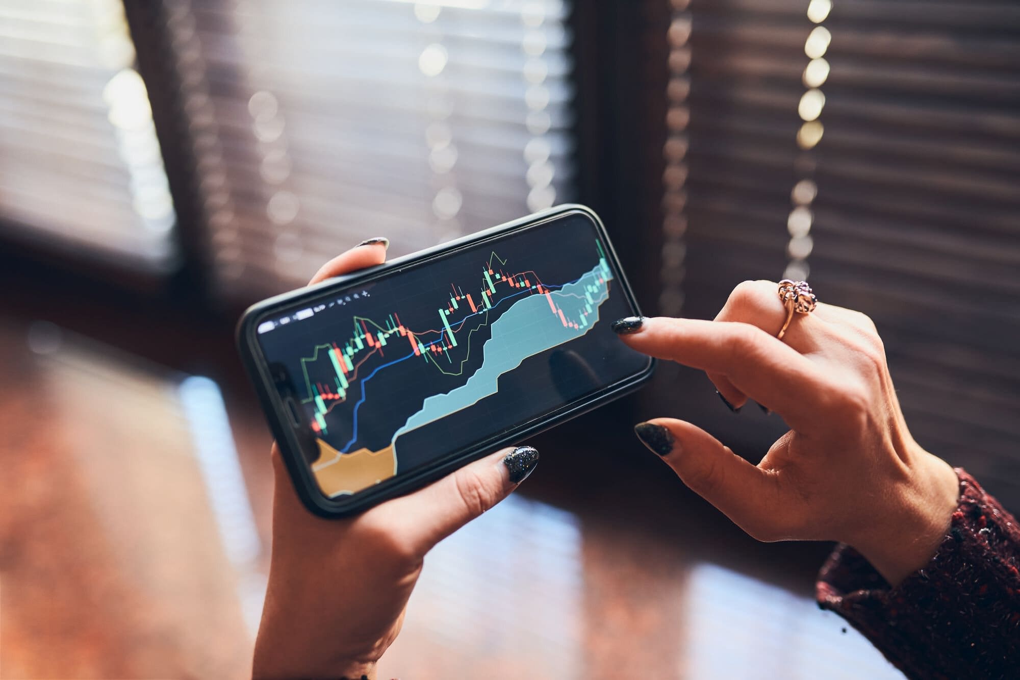 Hands of a young white woman investing trading on stock market using investing application on smartphone-Investing in Equity Funds