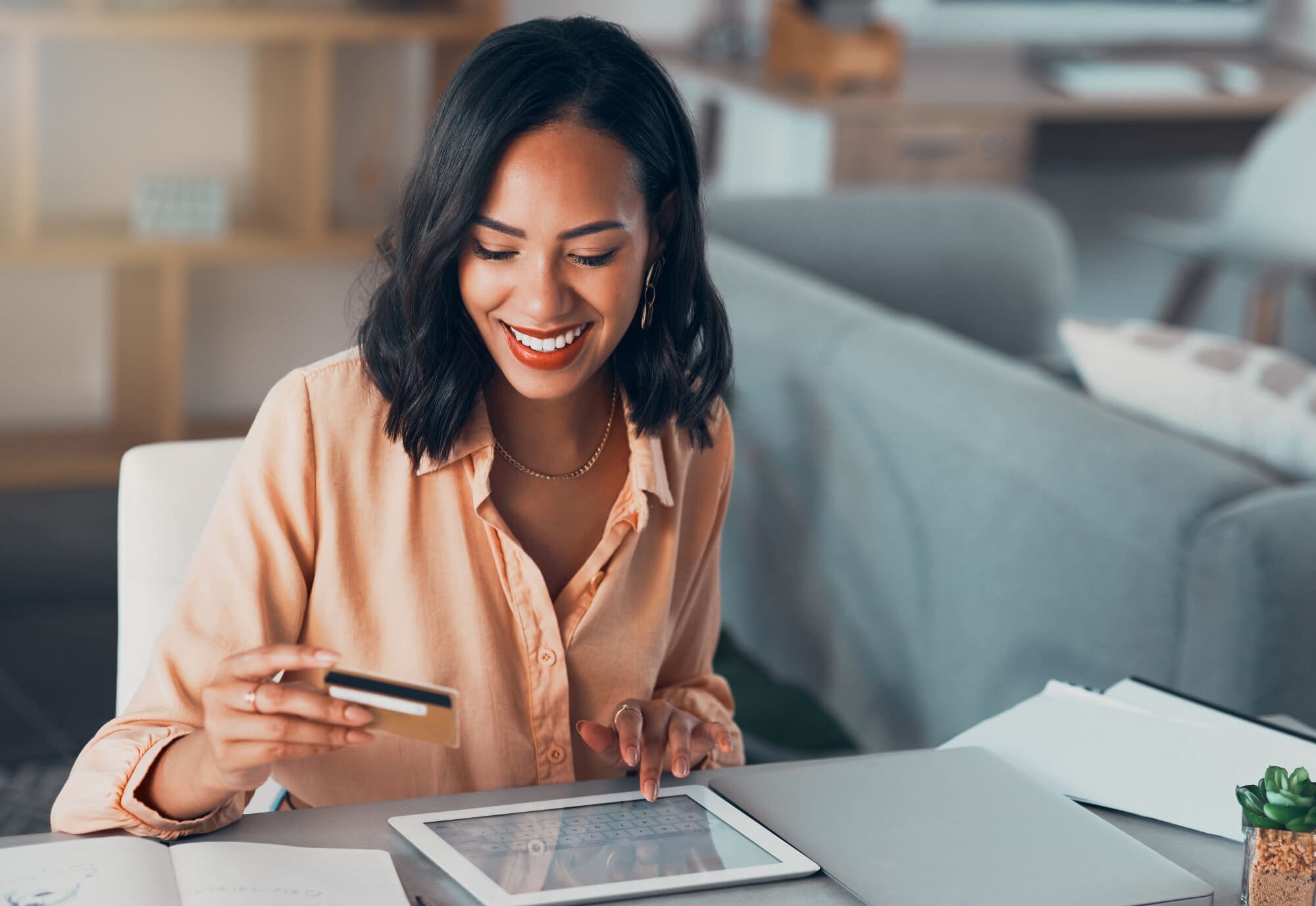young african woman smiling shopping for online purchase with credit card intentional spending