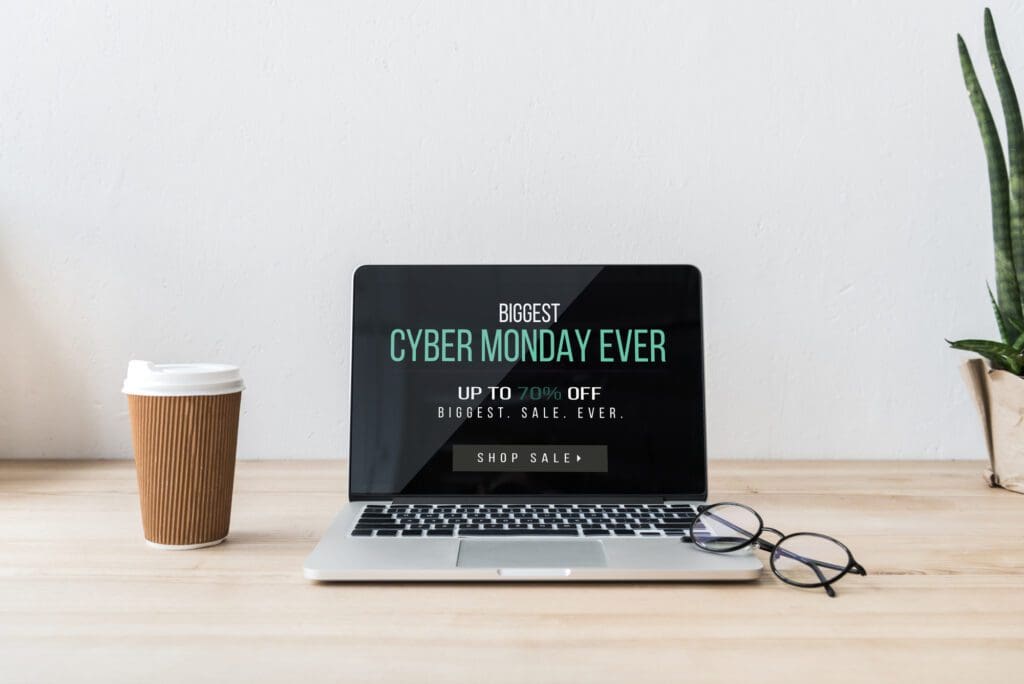 Workplace with laptop computer showing Cyber Monday Sale