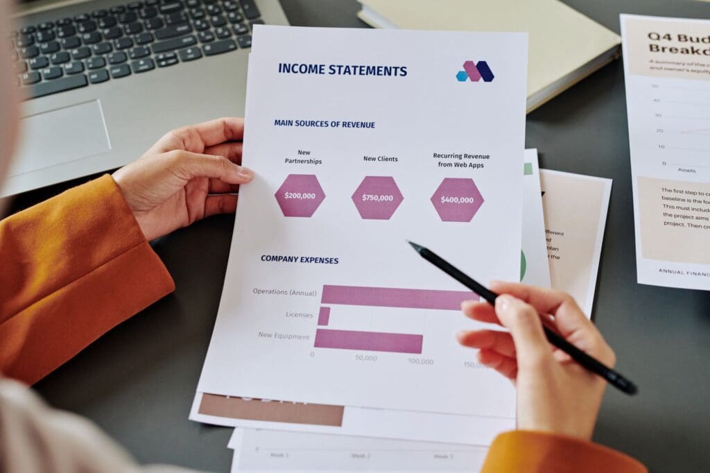 Hands of young female accountant pointing at document with chart and diagrams