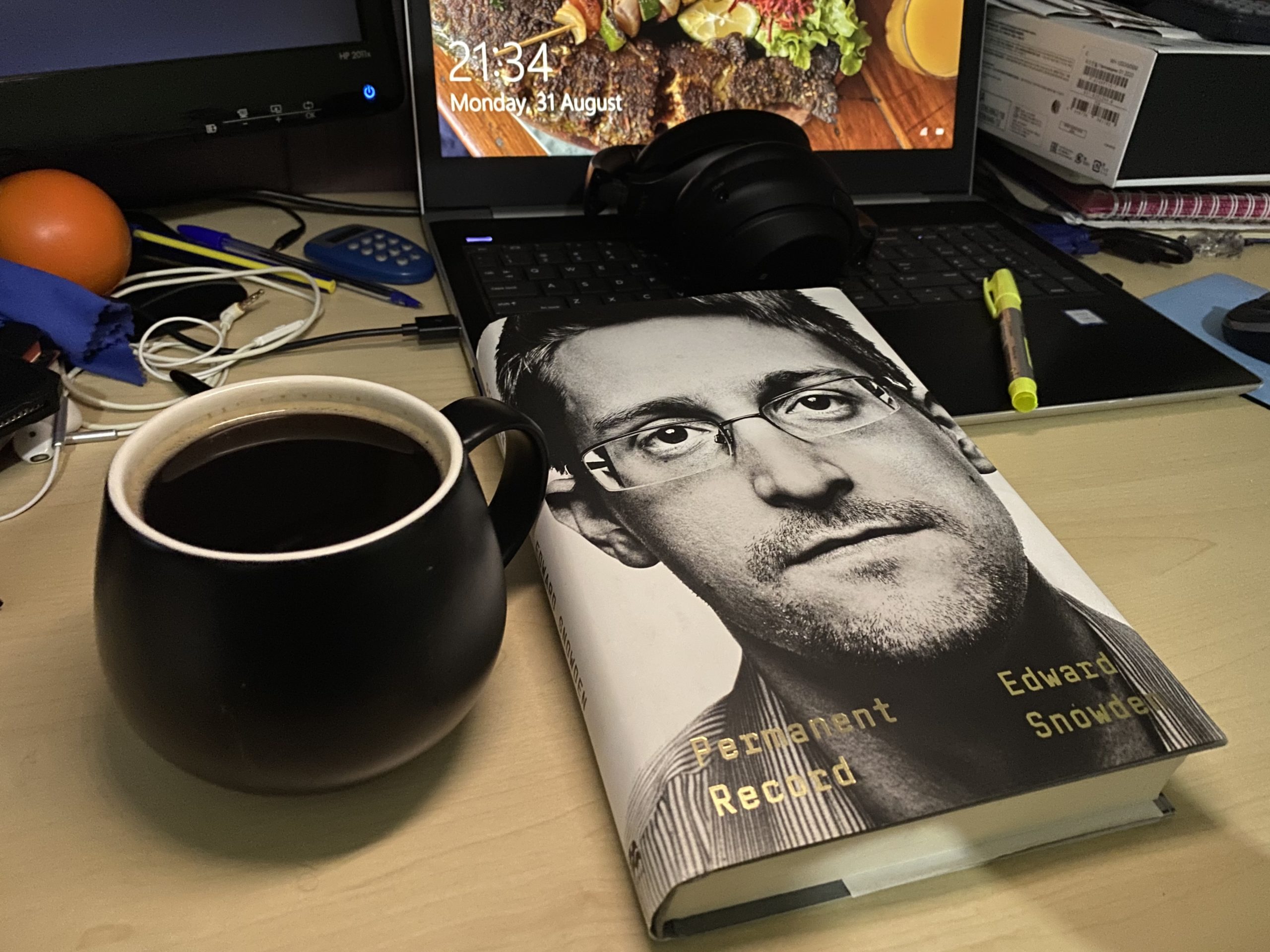 Copy of the Permanent Record by Edward Snowden on an office desk with a cup of coffee on the side