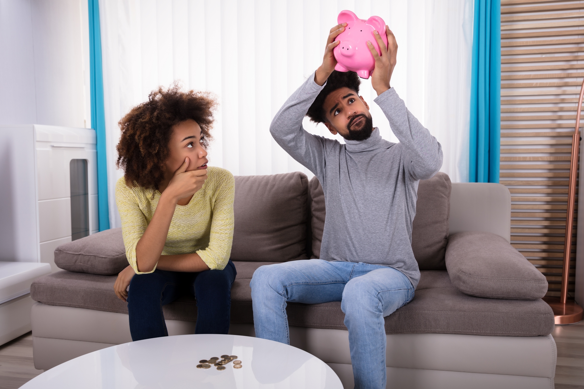 Couple looking at piggy bank distressed
