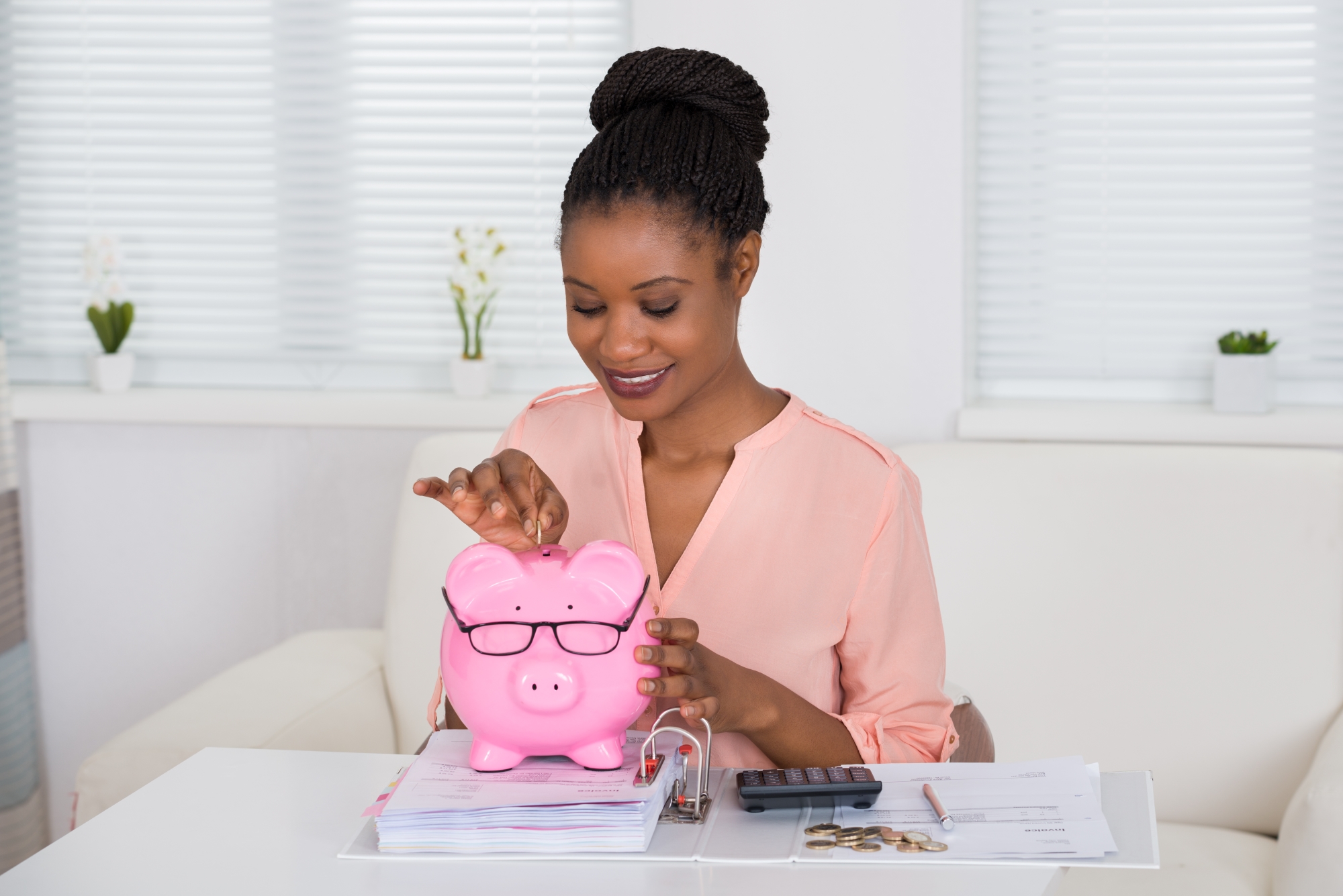 A lady putting money in a piggy bank
