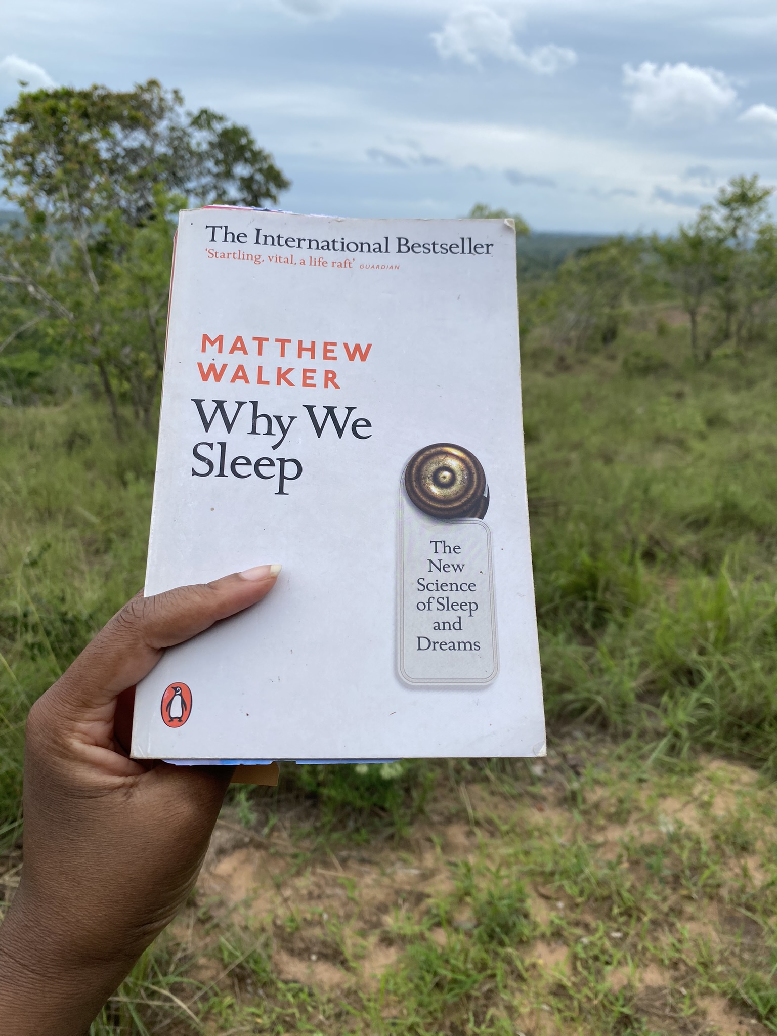 a hand holding a copy of Why We Sleep by Matthew Walker