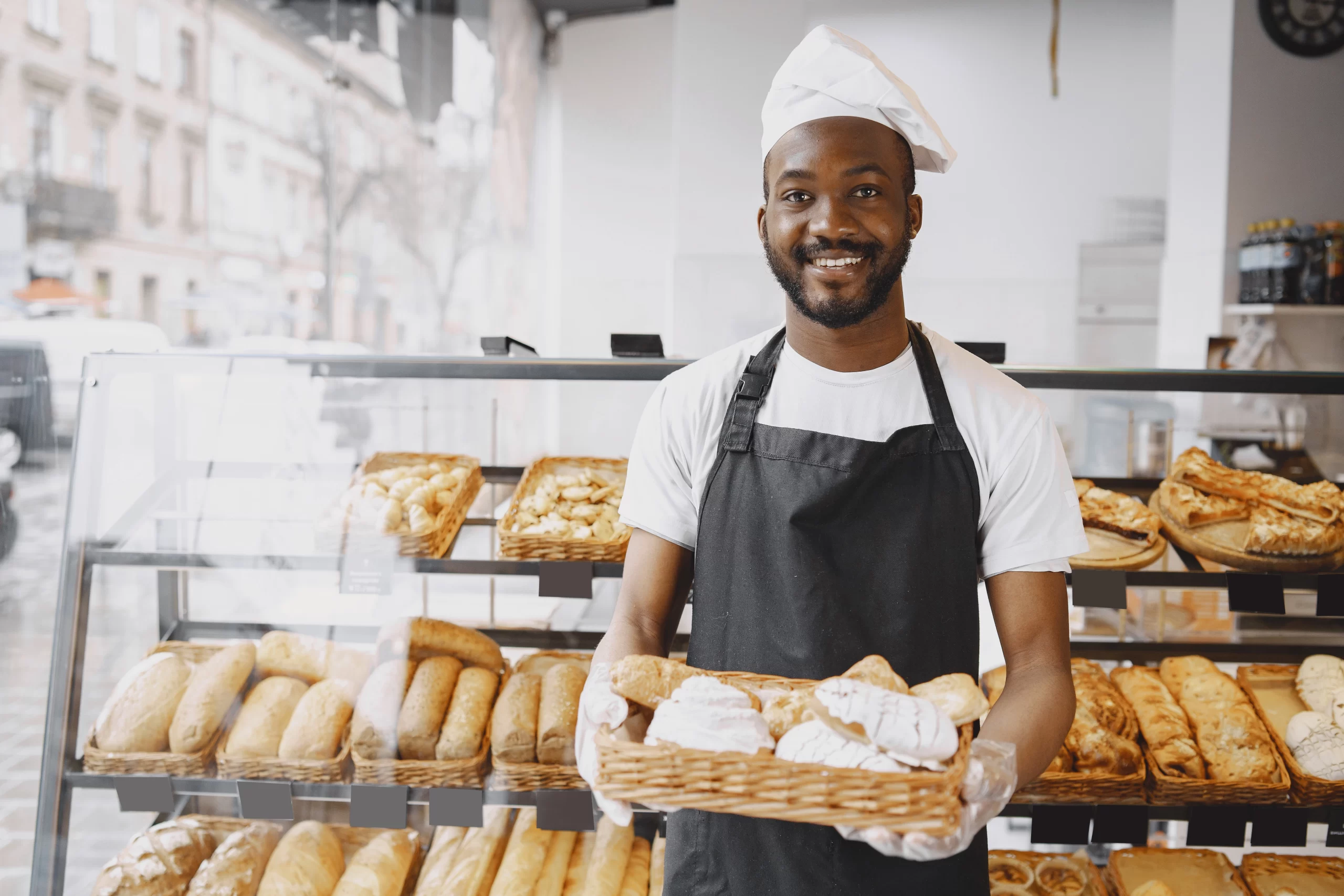 Young African man in front of a pastry display for a bakery idea