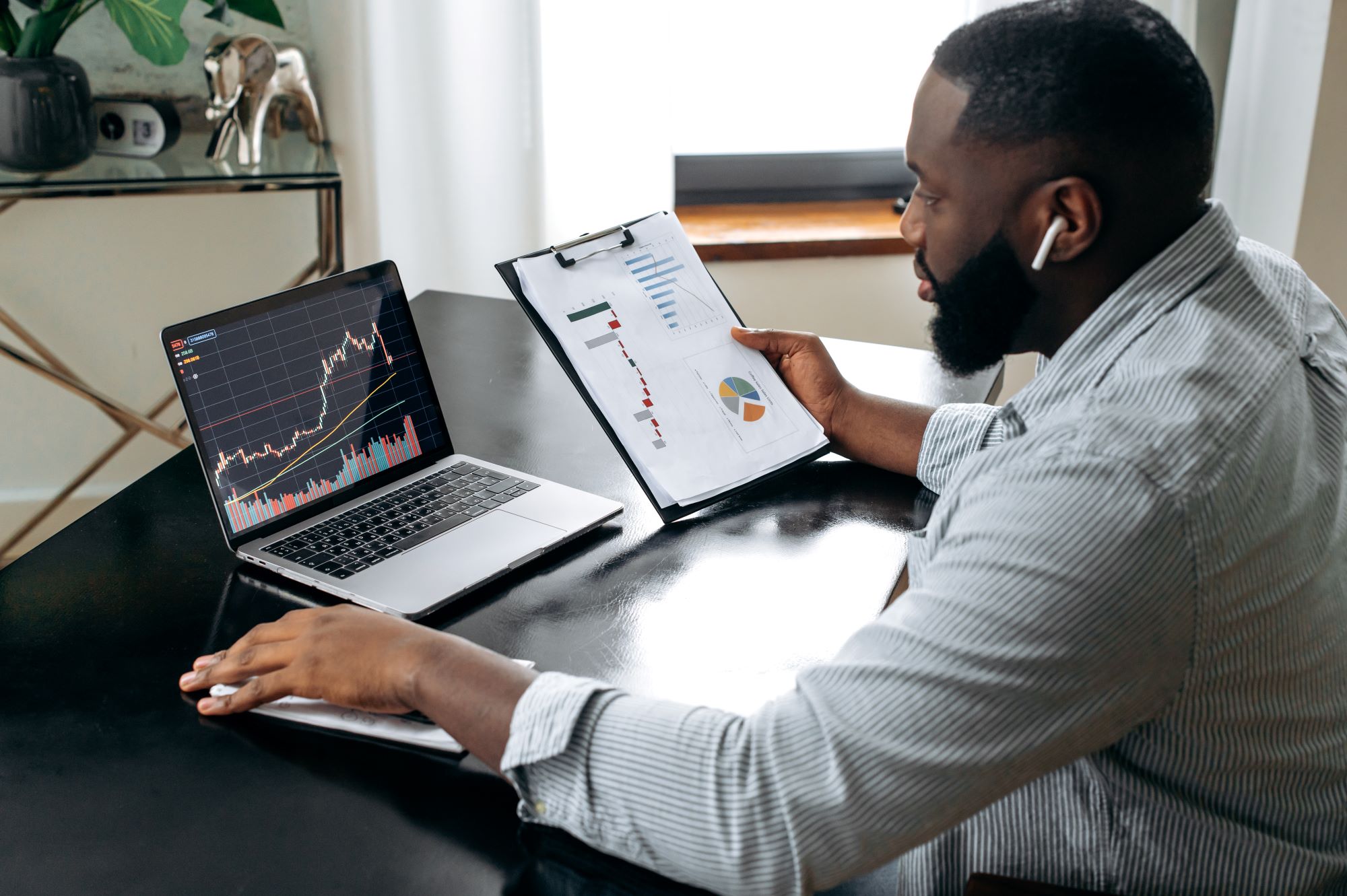 young black man checking a stocks age on their laptop