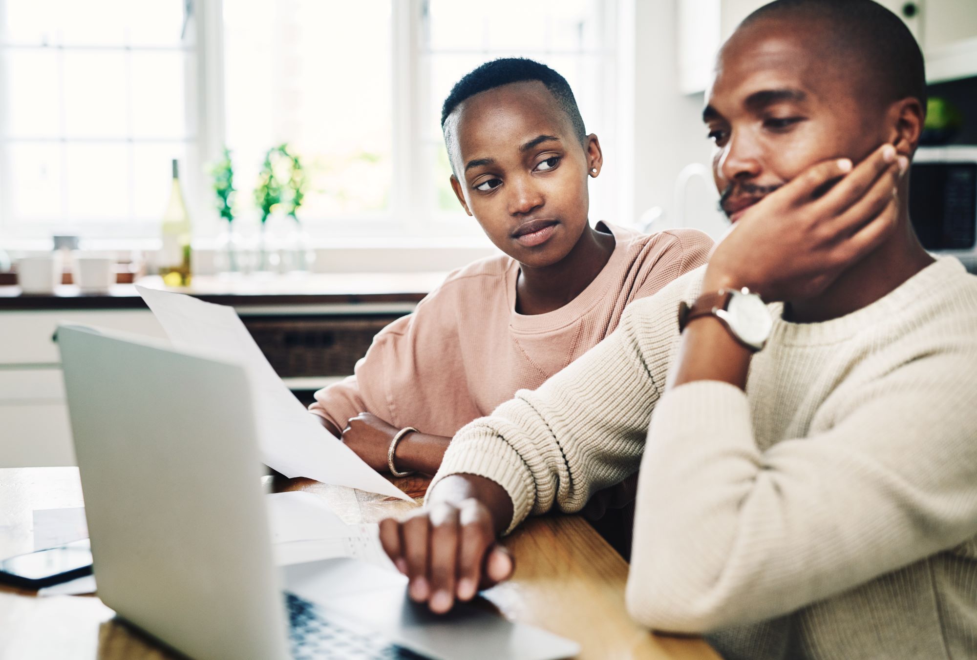 Shot of a young couple looking stressed while going over their finances on a laptop at home-Financial Goal Setting for Couples