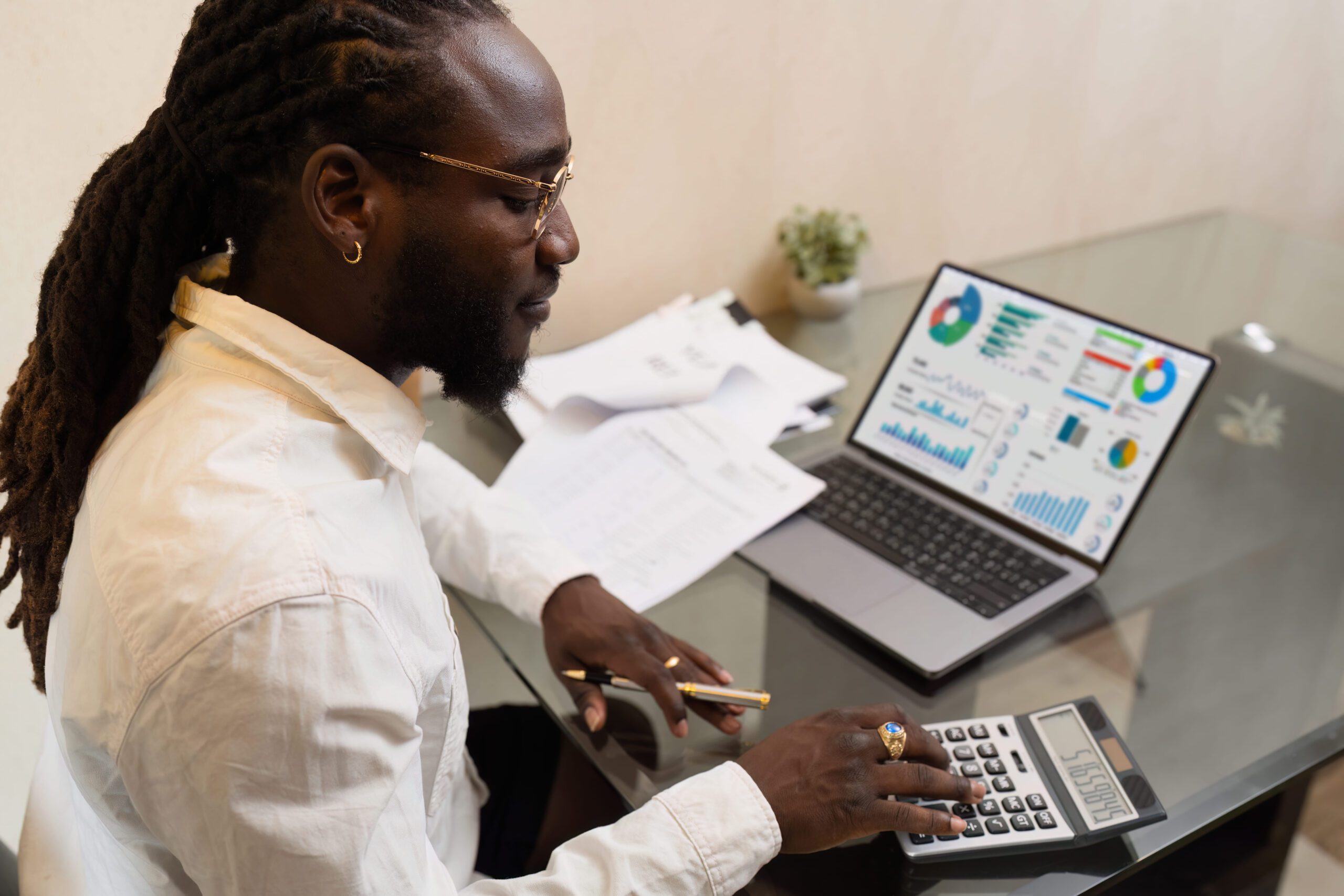 Business man using a calculator to calculate numbers on a company's financial documents-General Ledger