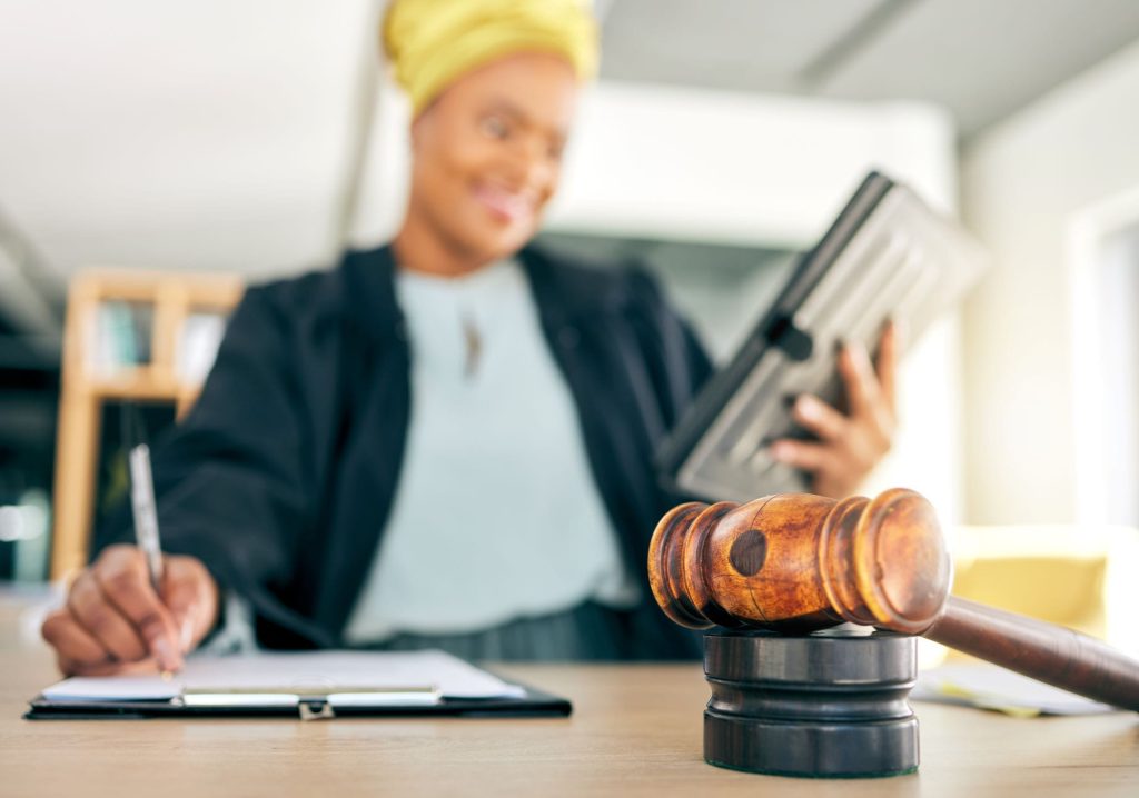 Judge, hammer and woman on tablet writing legal notes, checklist and compliance documents